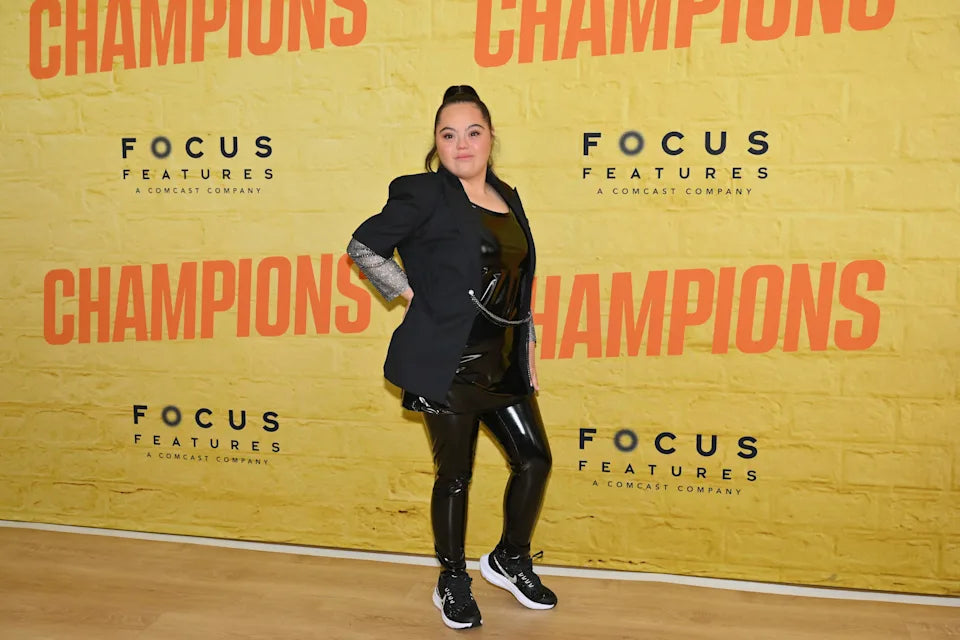 Madison posing confidently on the red carpet in front of a Focus Features “Champions” event backdrop.